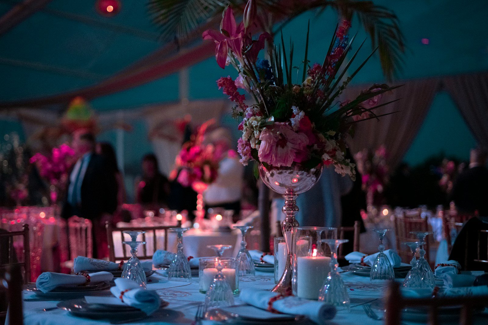 a table with a vase of flowers and candles on it